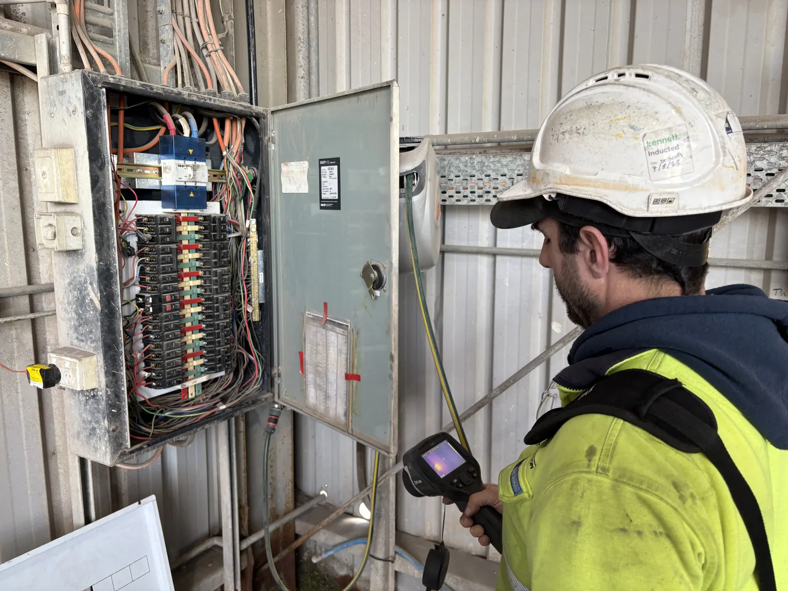 Industrial electrician fault finding inside an electrical control cabinet